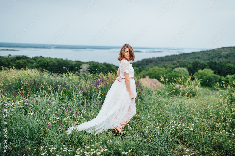beautiful girl in white dress lies in green grass