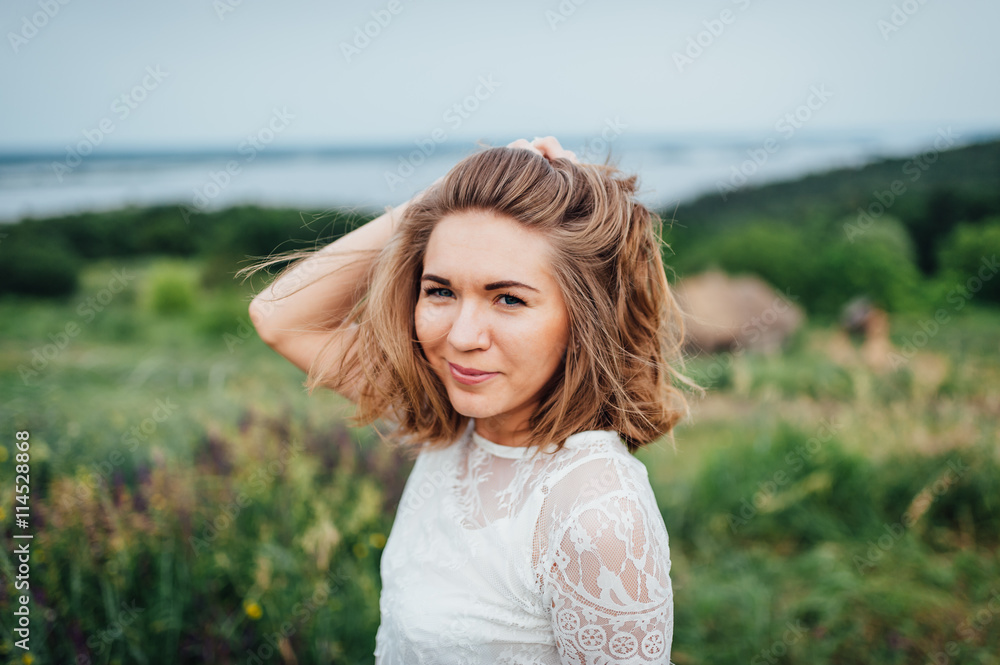 beautiful girl in white dress lies in green grass