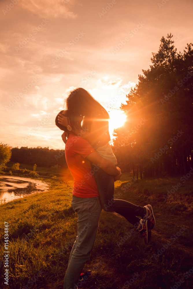 Fototapeta premium Young couple at sunset in the park.