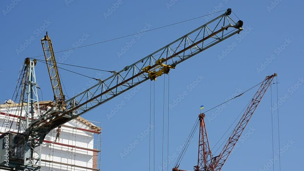 Construction cranes over houses. Construction cranes over houses.