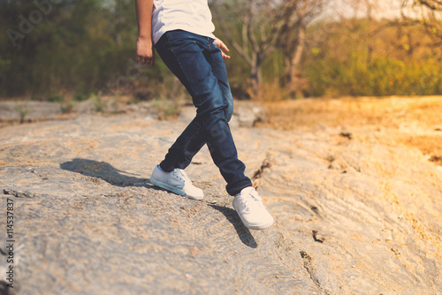 Boy walking on the rocky land.