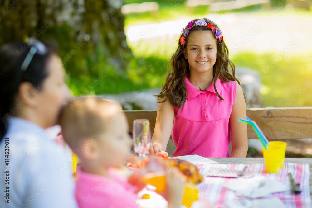 Mother with children enjoying on picnic sitting on a bench Mother with children enjoying on picnic sitting on a bench