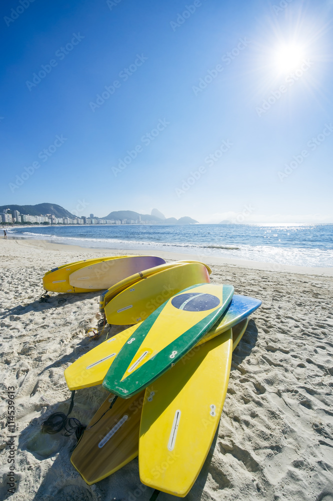 Brazilian flag stand up paddle surfboards stacked on the beach at Copacabana, Rio de Janeiro Brazil Brazilian flag stand up paddle surfboards stacked on the beach at Copacabana, Rio de Janeiro Brazil
