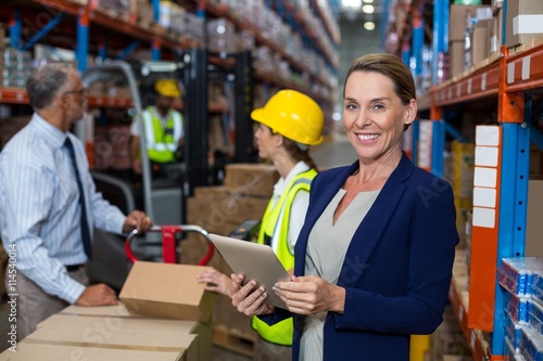 Business woman standing in front warehouse worker © WavebreakMediaMicro