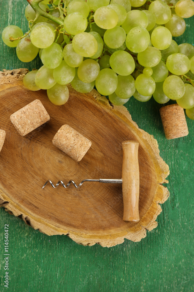 Wine corks and tailspin with bunch of grapes on wooden background Wine corks and tailspin with bunch of grapes on wooden background