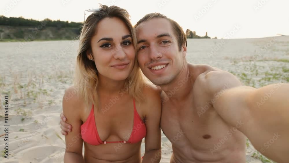 young couple doing selfie on the beach at sunset young couple doing selfie on the beach at sunset