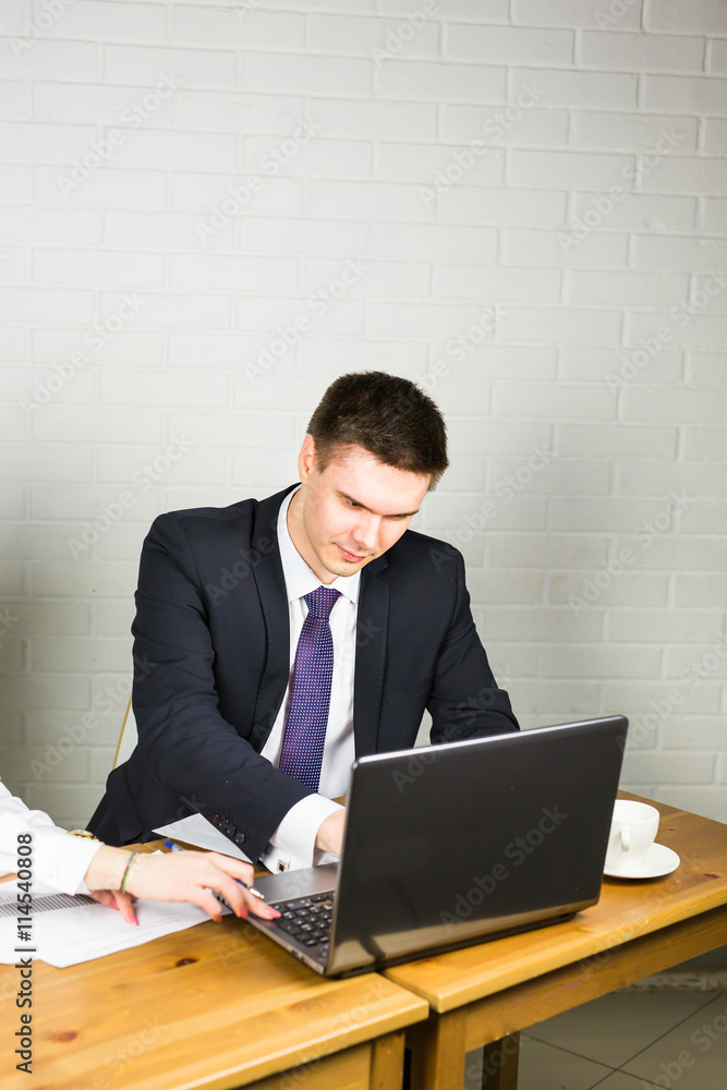 Handsome businessman working with laptop in office Handsome businessman working with laptop in office