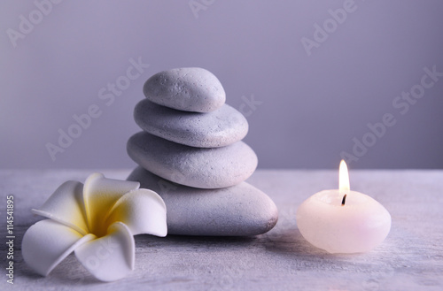 White spa stones with candle on gray background