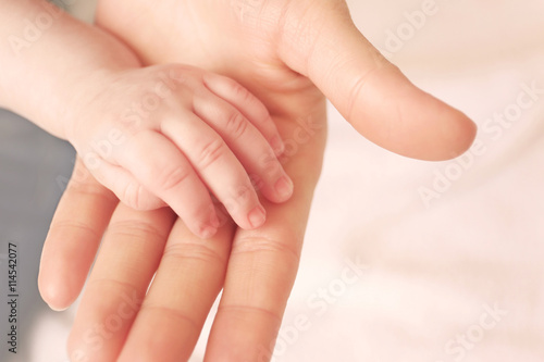 Child hand holding parent hand, closeup