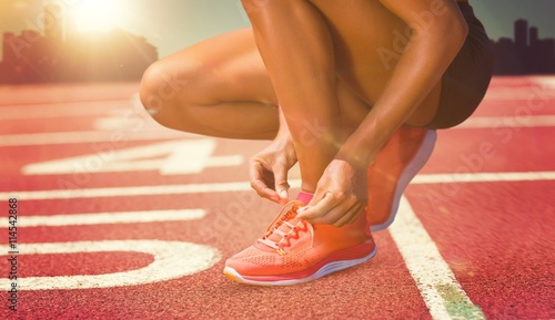 Composite image of close up of sportswoman is lacing shoes 