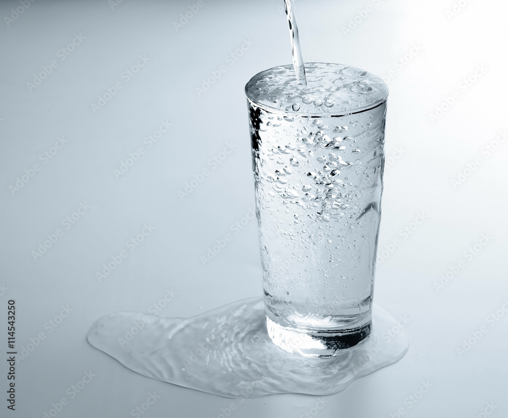 Pouring water into glass on white background Pouring water into glass on white background