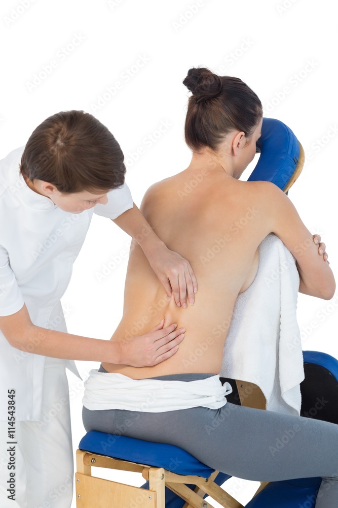 Masseuse giving back massage to naked woman Masseuse giving back massage to naked woman