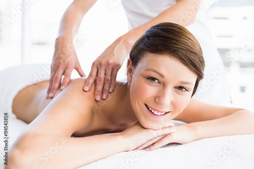 Portrait of happy woman receiving back massage