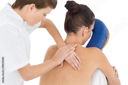 Masseuse giving massage to naked woman