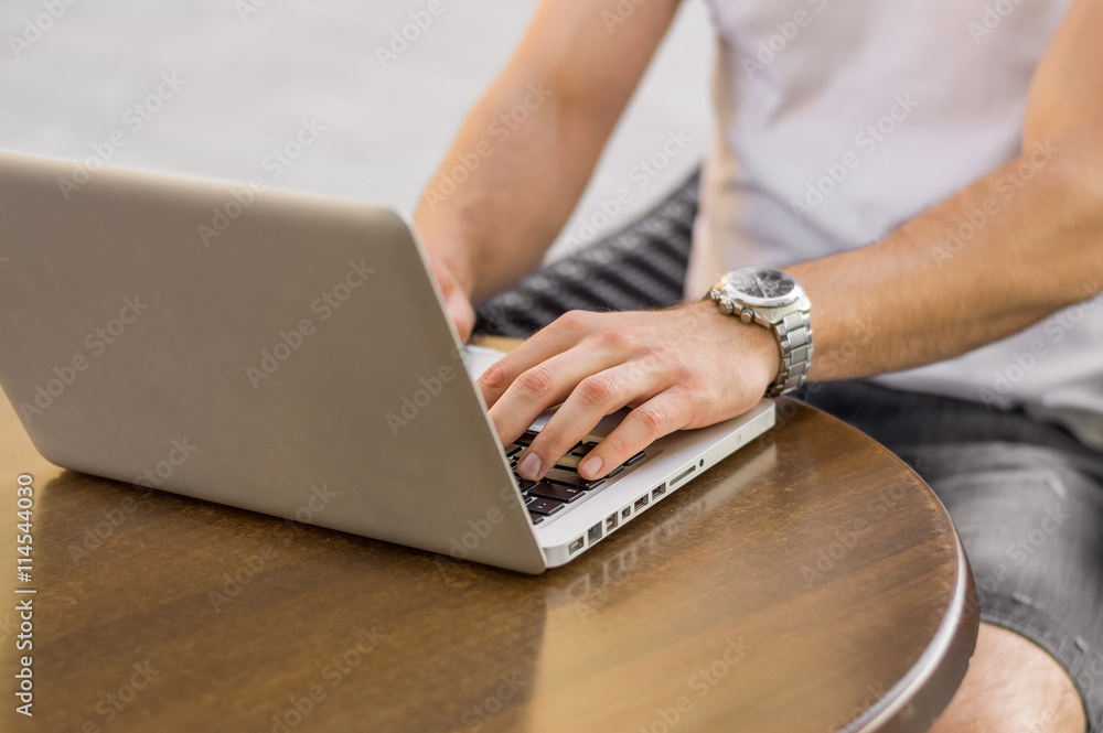 Fototapeta premium Man's hands typing on laptop keyboard