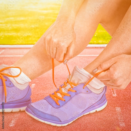 Composite image of athlete woman tying her running shoes