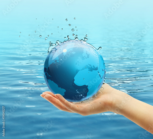 Female hand holding globe on blue water background