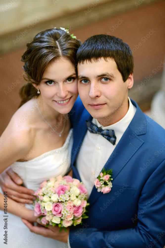 Wedding couple indoors is hugging each other. Beautiful model girl in white dress. Man in suit. Beauty bride with groom. Female and male portrait. Woman with lace veil. Cute lady and handsome guy Wedding couple indoors is hugging each other. Beautiful model girl in white dress. Man in suit. Beauty bride with groom. Female and male portrait. Woman with lace veil. Cute lady and handsome guy