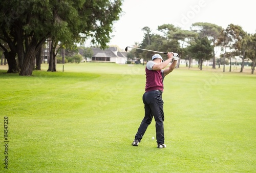 Rear view of golfer raising his golf club © WavebreakmediaMicro