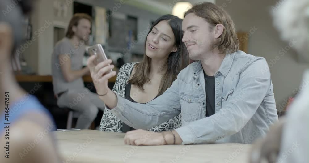 Man and woman taking self photograph with mobile phone in pub Man and woman taking self photograph with mobile phone in pub