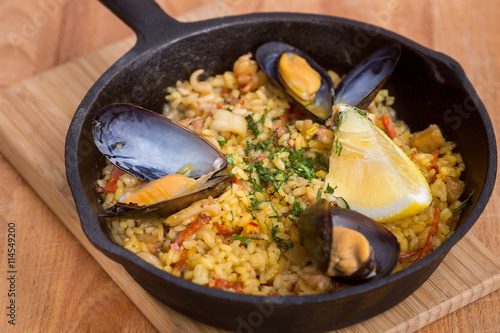 Paella with mussels on pan
