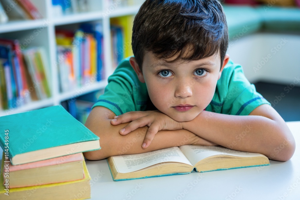 Elementary boy with book in school library Elementary boy with book in school library