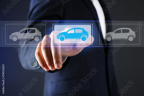 Businessman touching icon of car on virtual screen