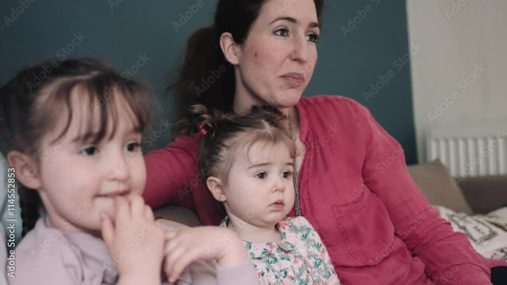 Family with children watching television in living room Family with children watching television in living room