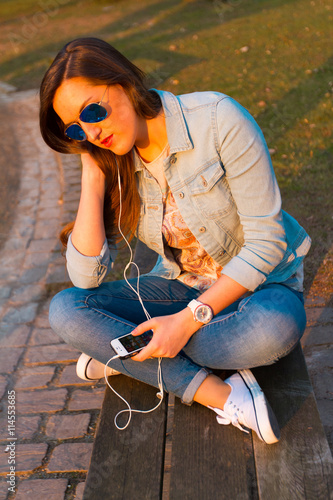 Image of beautiful woman listening music outdoor