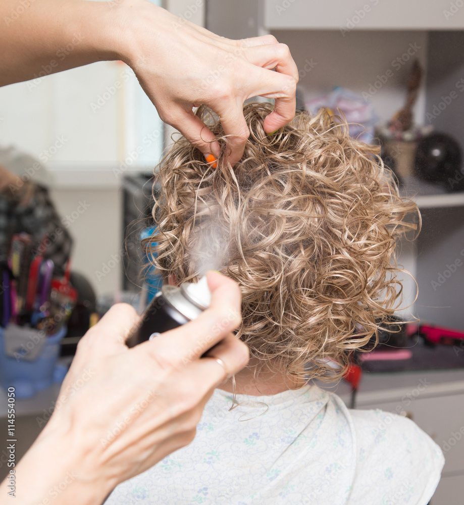 Naklejka premium Female hair lacquer in a beauty salon