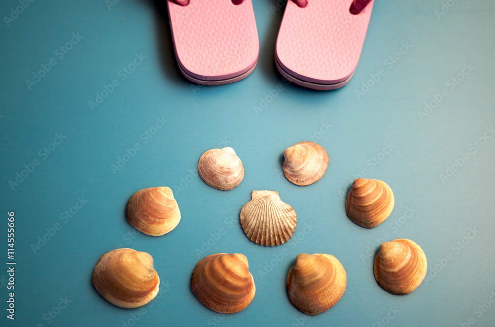 Conchiglia e sandali da mare. Vacanze estive. Immagine simbolica per attività turistica. Conchiglia e sandali da mare. Vacanze estive. Immagine simbolica per attività turistica.