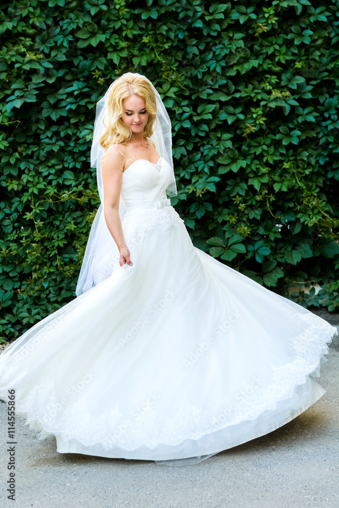 Bride posing on the background of shrubs Bride posing on the background of shrubs