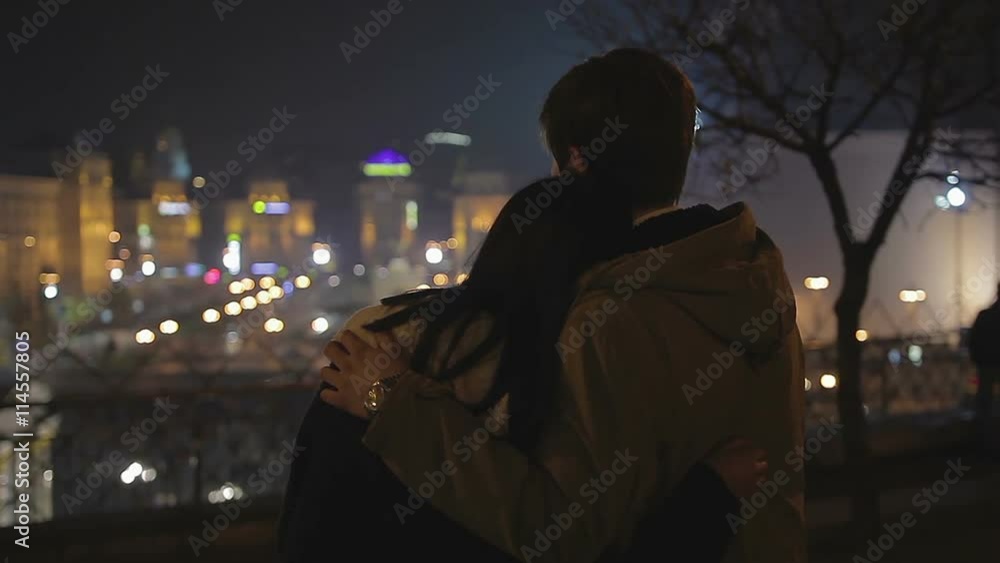 Couple in love hugging gently, looking to future together, night cityscape Couple in love hugging gently, looking to future together, night cityscape