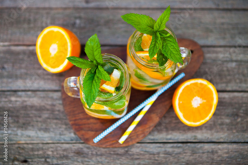 Fresh cocktail with orange, mint and ice, selective focus