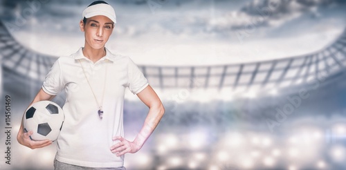 Composite image of female athlete holding a soccer ball