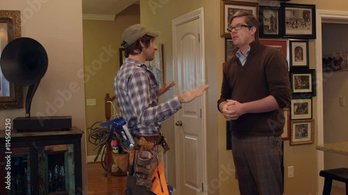 A contractor and home owner shake hands inside a house photo
