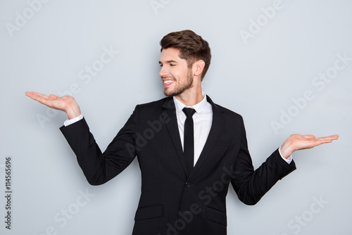 Young happy businessman gesturing with hands and showing balance