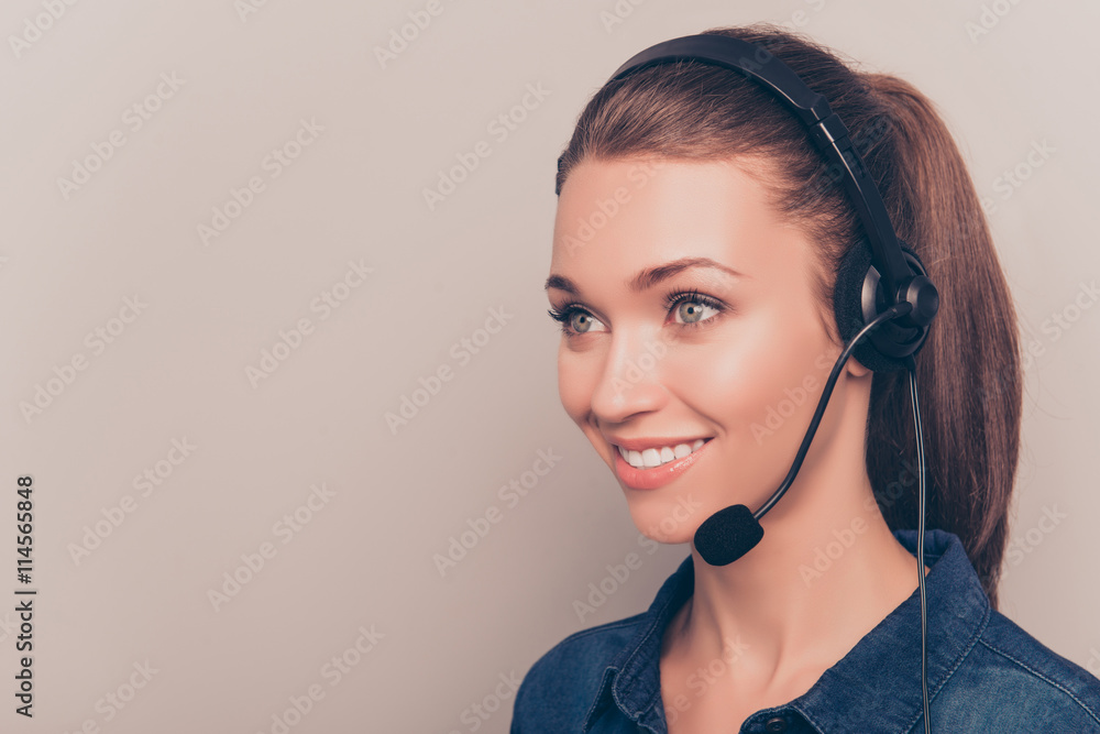 Pretty smiling secretary in headphones isolated on gray backgro Pretty smiling secretary in headphones isolated on gray backgro