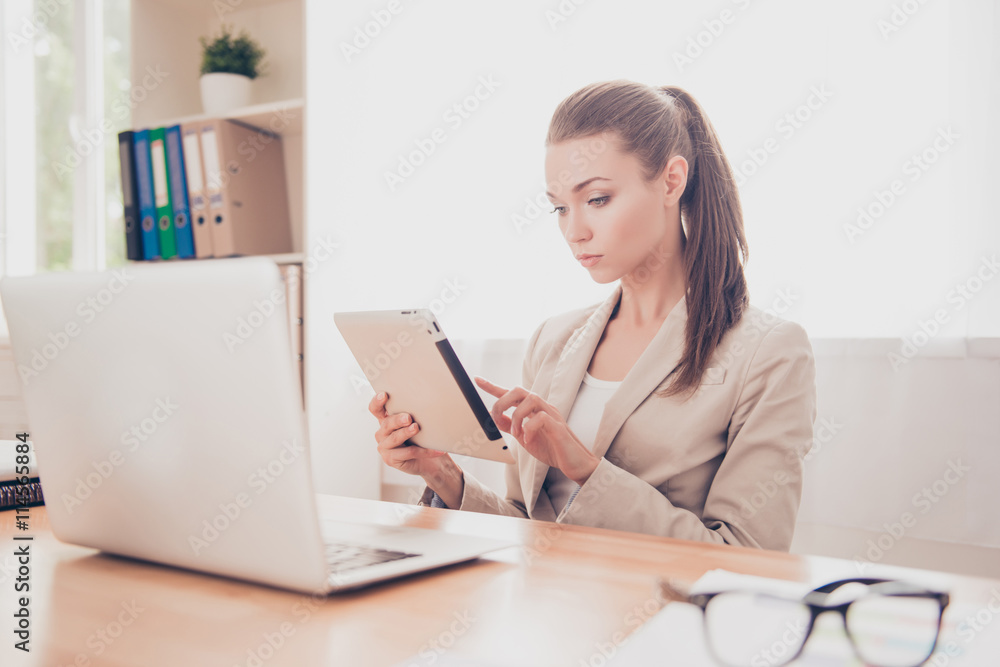 Fototapeta premium Concentrated pretty woman reading news on digital tablet