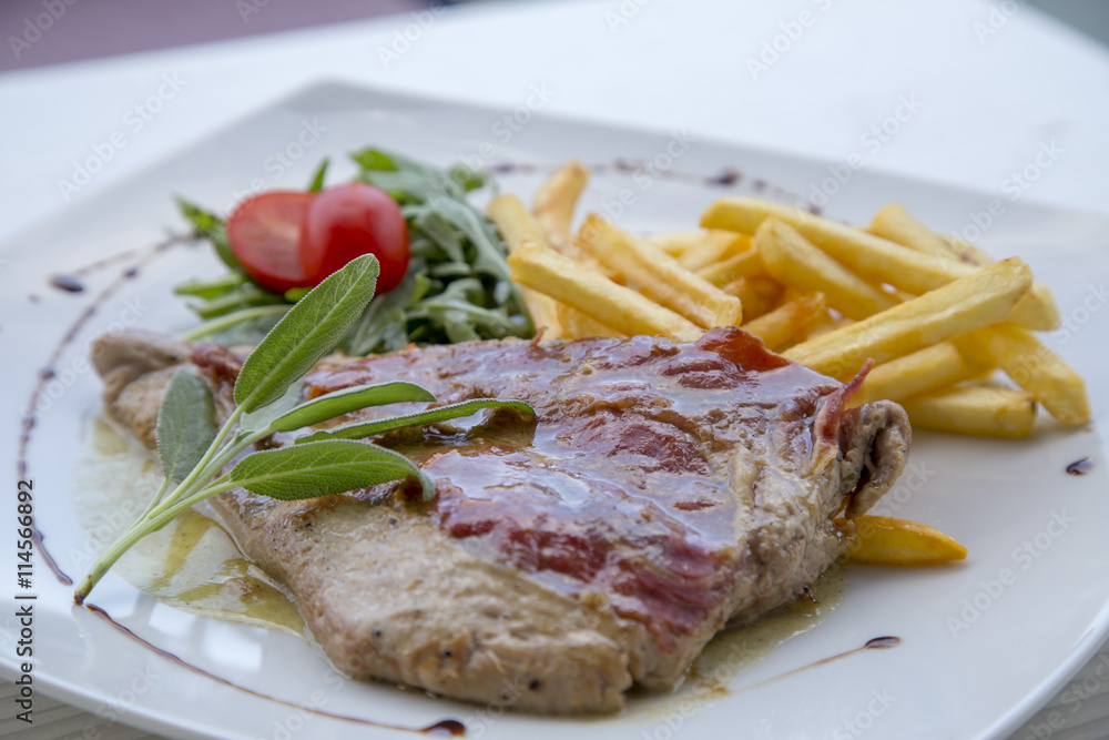 Pork steak in white plate and french fries . Pork steak in white plate and french fries .