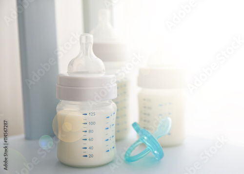 Baby milk bottles and pacifier on white background