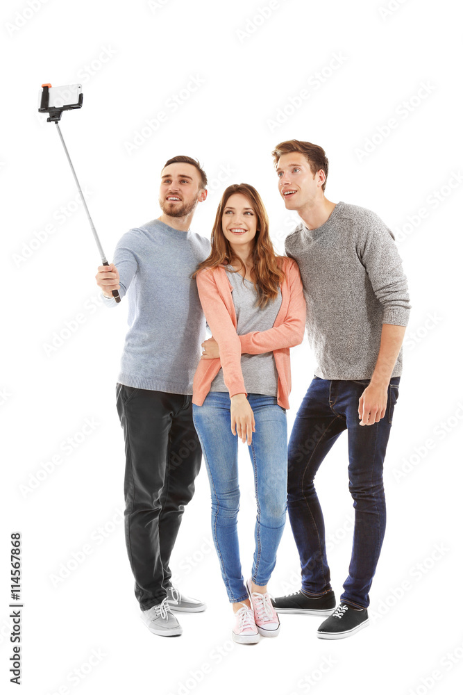 Obraz premium Young cheerful friends taking selfie isolated on white