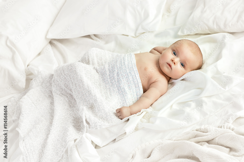 Portrait of a charming toddler lying on the bright sheet Portrait of a charming toddler lying on the bright sheet