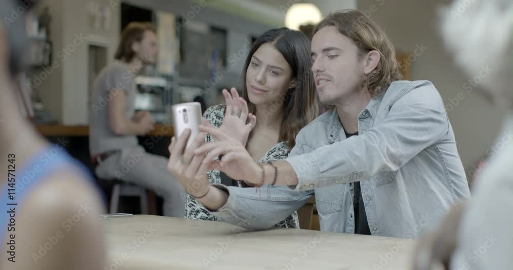 Man and woman taking self photograph with mobile phone in pub Man and woman taking self photograph with mobile phone in pub
