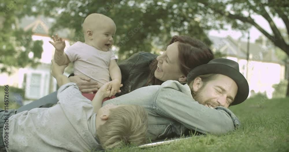 Family lying on grass and having fun outside Family lying on grass and having fun outside