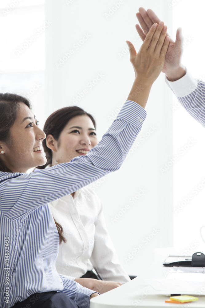 Businessmen and business women have a high five Businessmen and business women have a high five