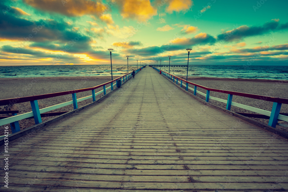 Perspective view of wooden pier over sea. Palanga city at sunset in autumn, Lithuania
