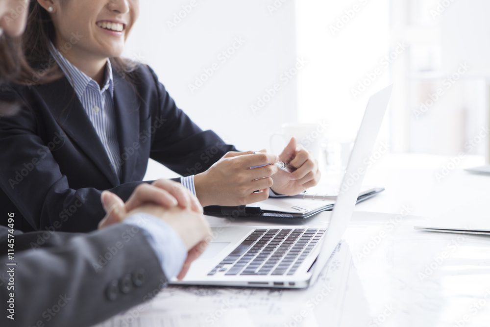 Two business woman is using a laptop in the office Two business woman is using a laptop in the office