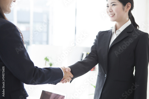 Business women are shaking hands with a smile