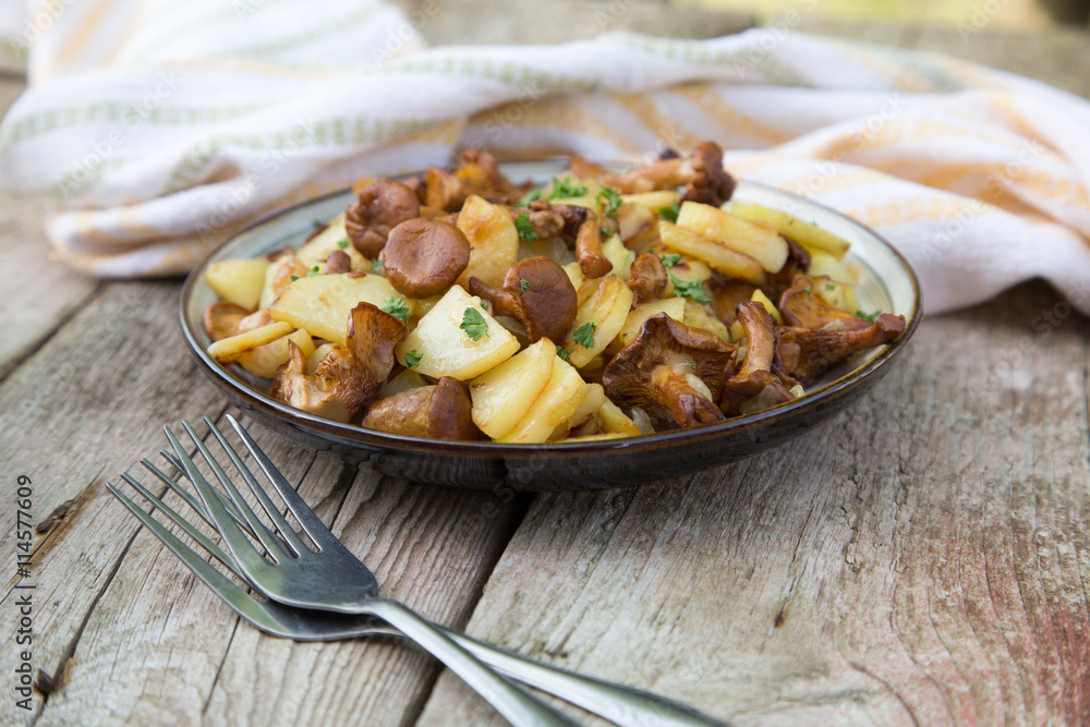 fried young potatoes with chanterelles mushrooms in bowl on old fried young potatoes with chanterelles mushrooms in bowl on old